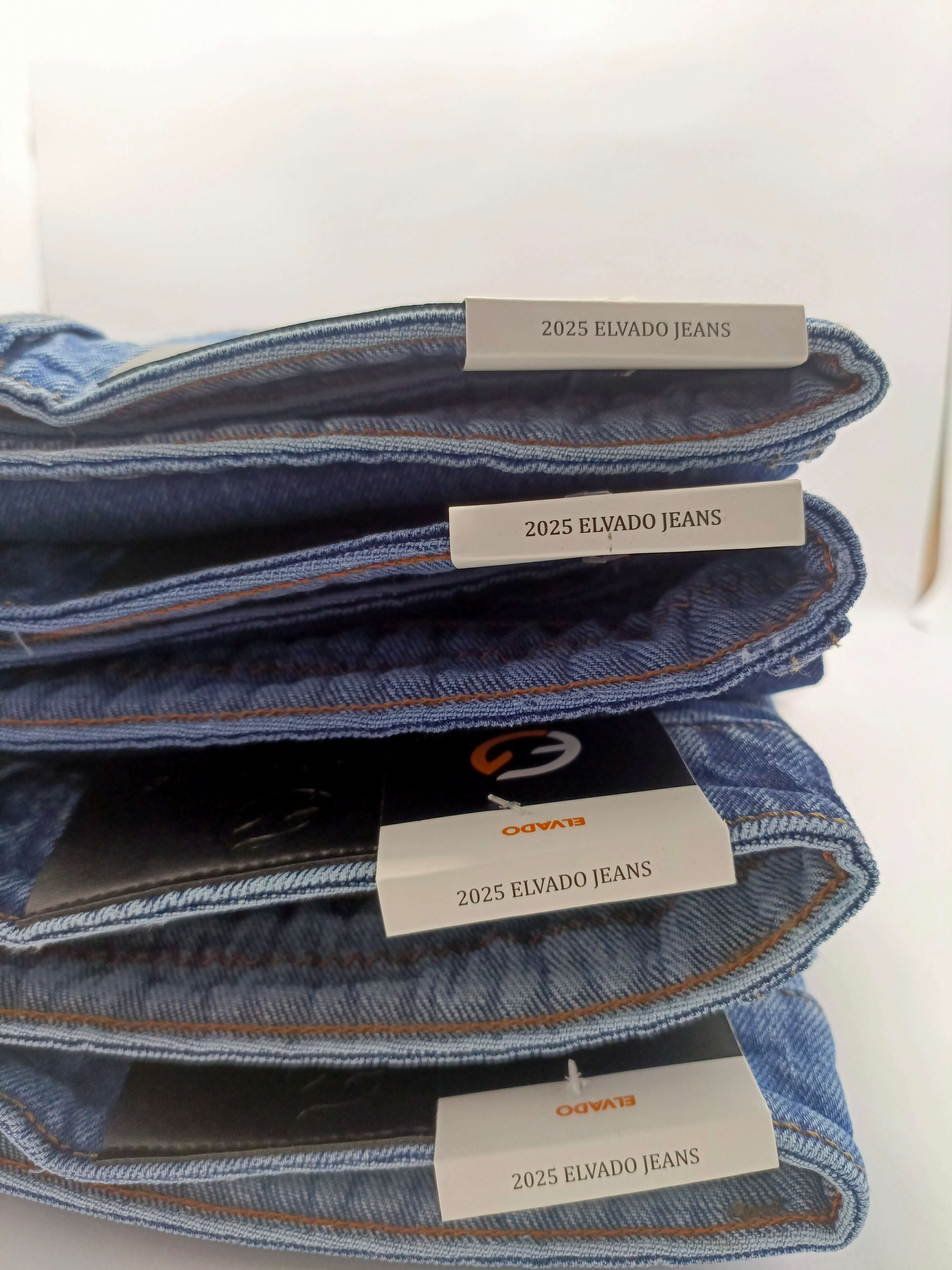 Dark indigo acid wash jeans stacked, featuring ELVADO JEANS labels, showcasing slim fit and stretchy cotton design.