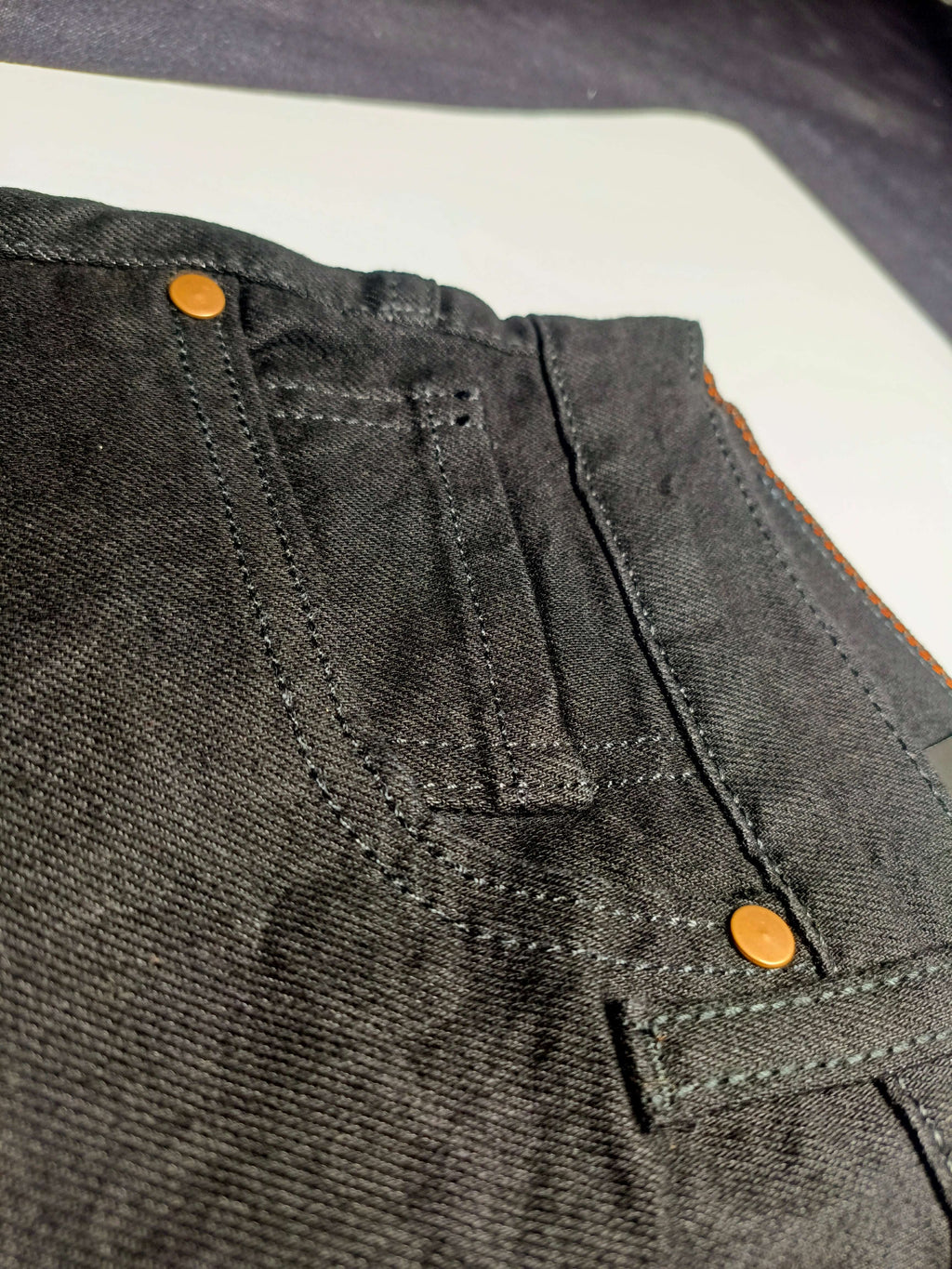 Premium Black Denim close-up of straight fit slim fit jeans detailing with stretchy fabric features.