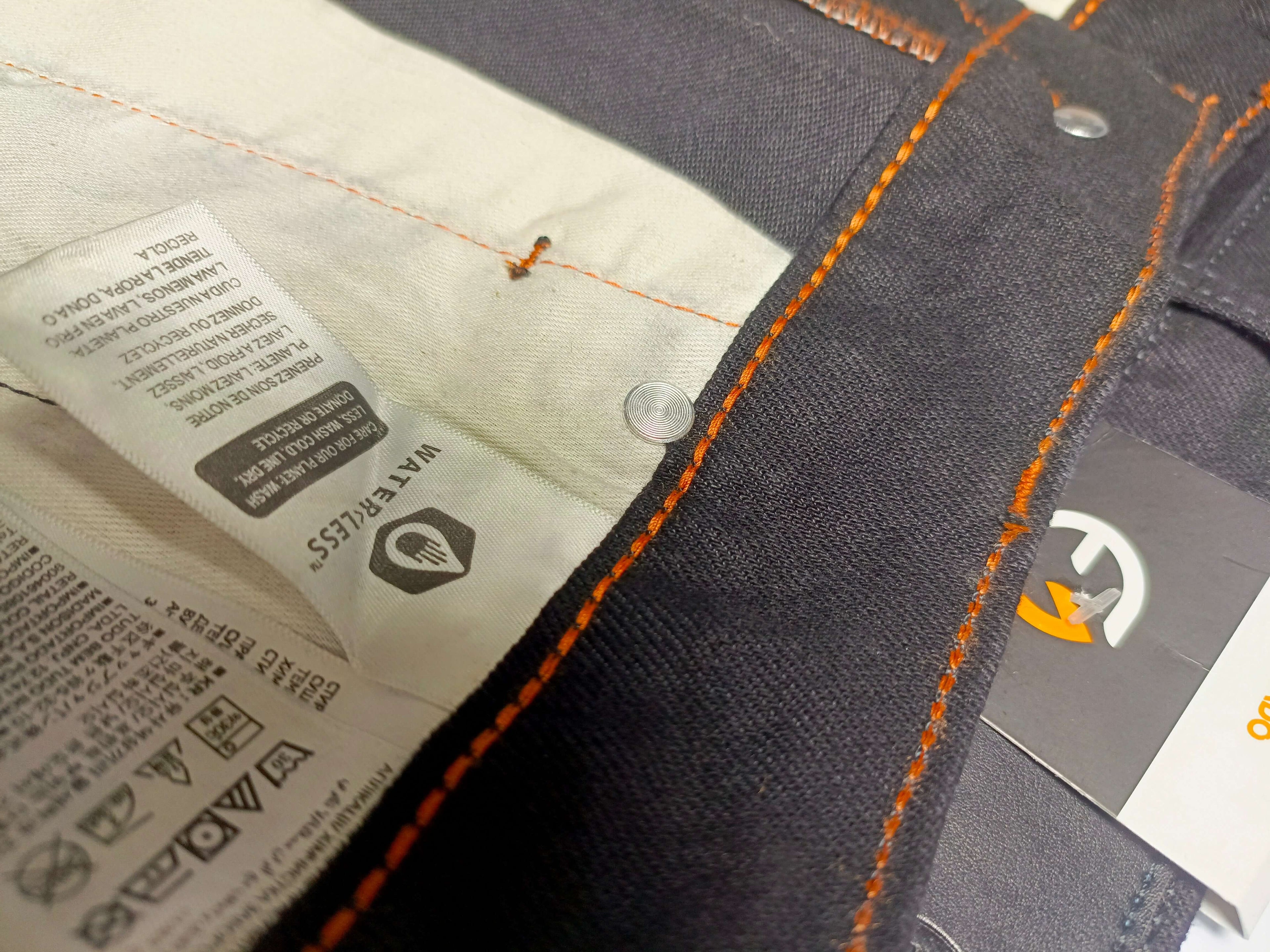 Premium Black Denim tag showing care instructions and stitching details for ELVADO's slim fit jeans.
